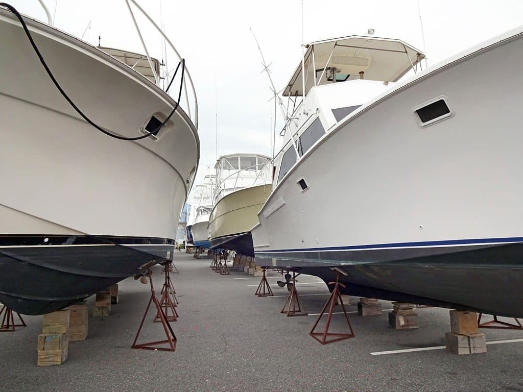 Photo of sport fishing boats that have been pulled out of the water and stored for the winter in Ocean City Maryland at a marina parking lot.  These boats fish for big game fish such as Marlin and Tuna which are not present in off the coast of Ocean City Maryland in the winter.  A few boats may fish for cold water fish such as Cod and Blackfish.